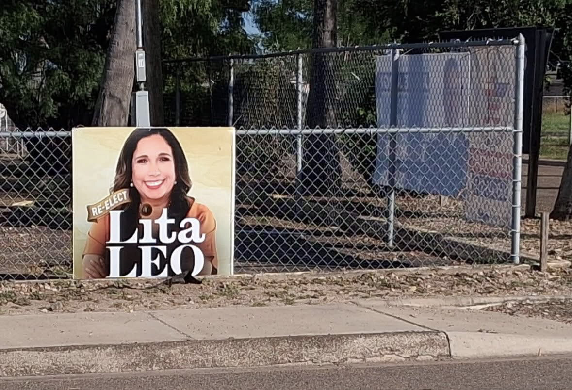 Lita Leo roadside campaign signage installed along a fence